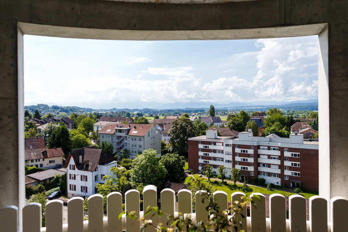 Blick aus einem Haus auf andere Wohnhäuser in Uster. Man sieht einige Wohnblocks und Grün rundherum.